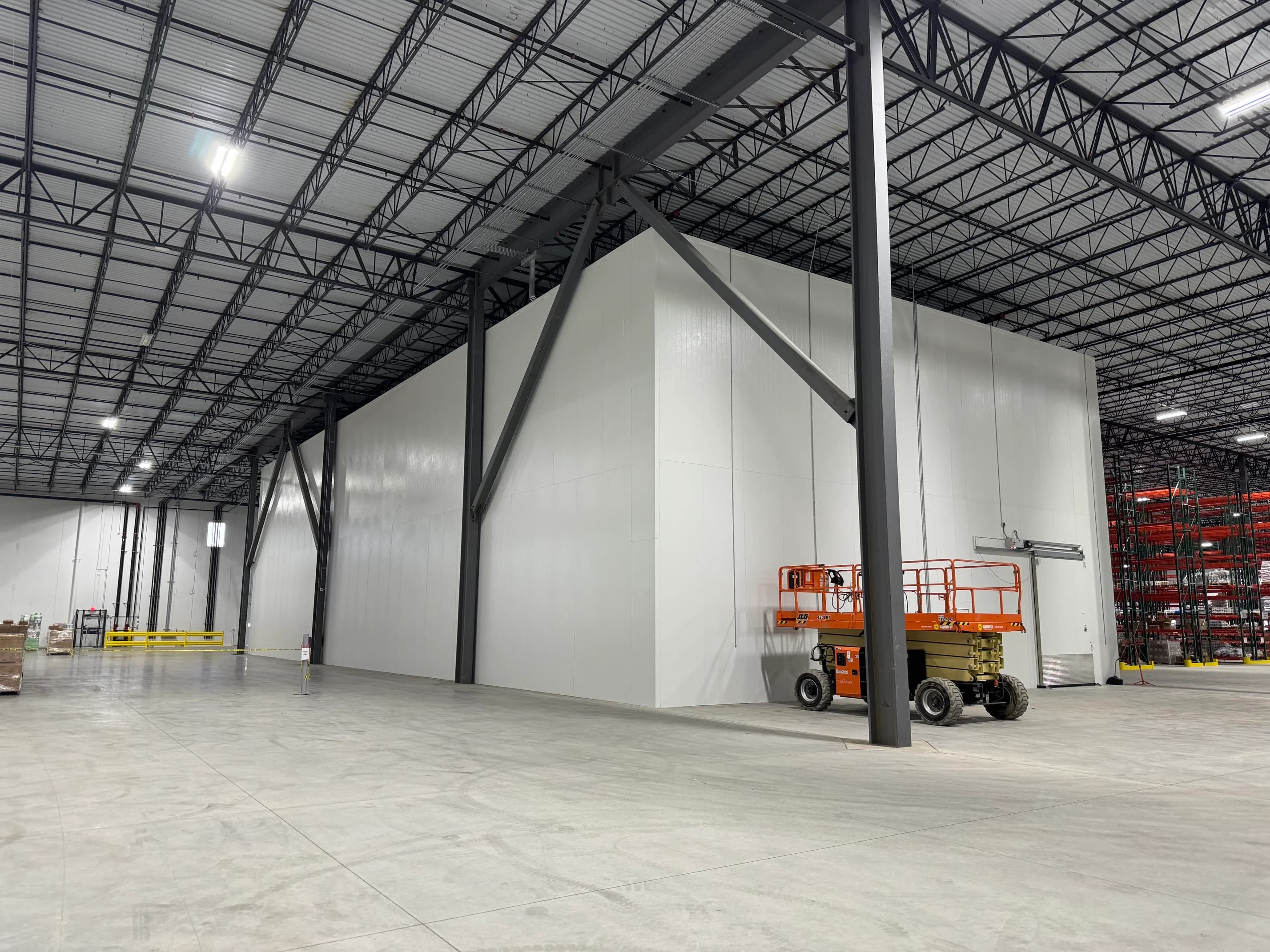 A large insulated cold-storage box built inside a distribution warehouse